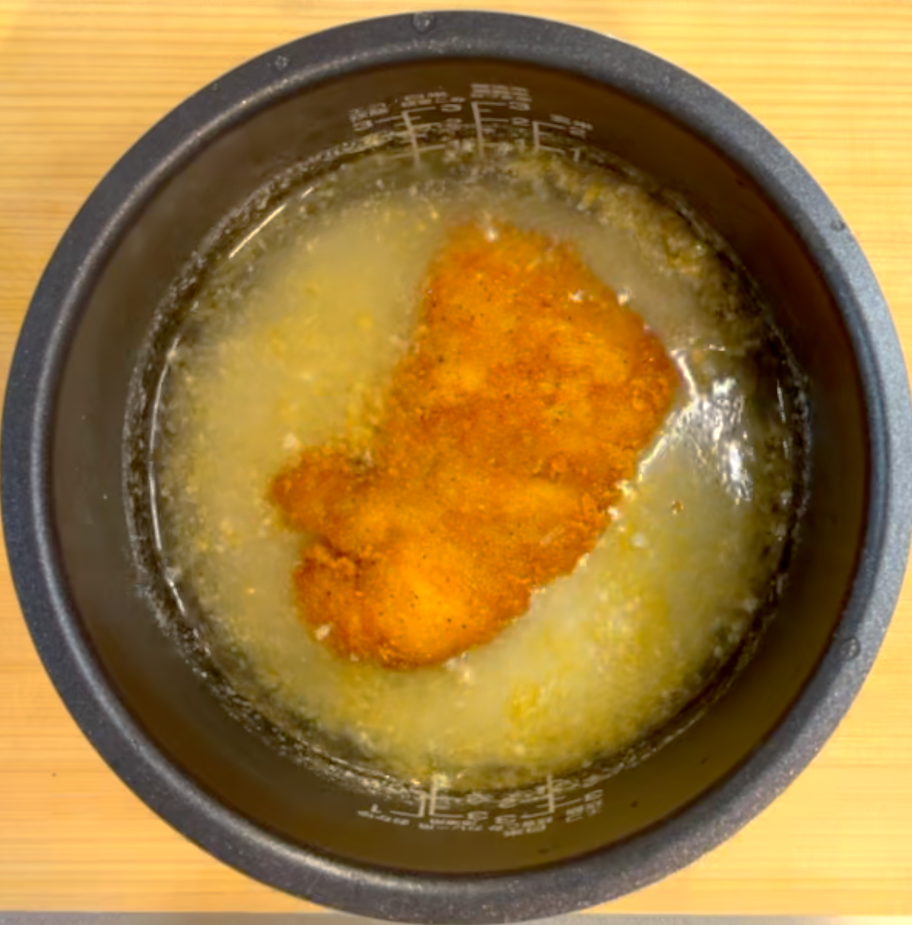 炊飯釜にファミチキをのせて炊飯する様子