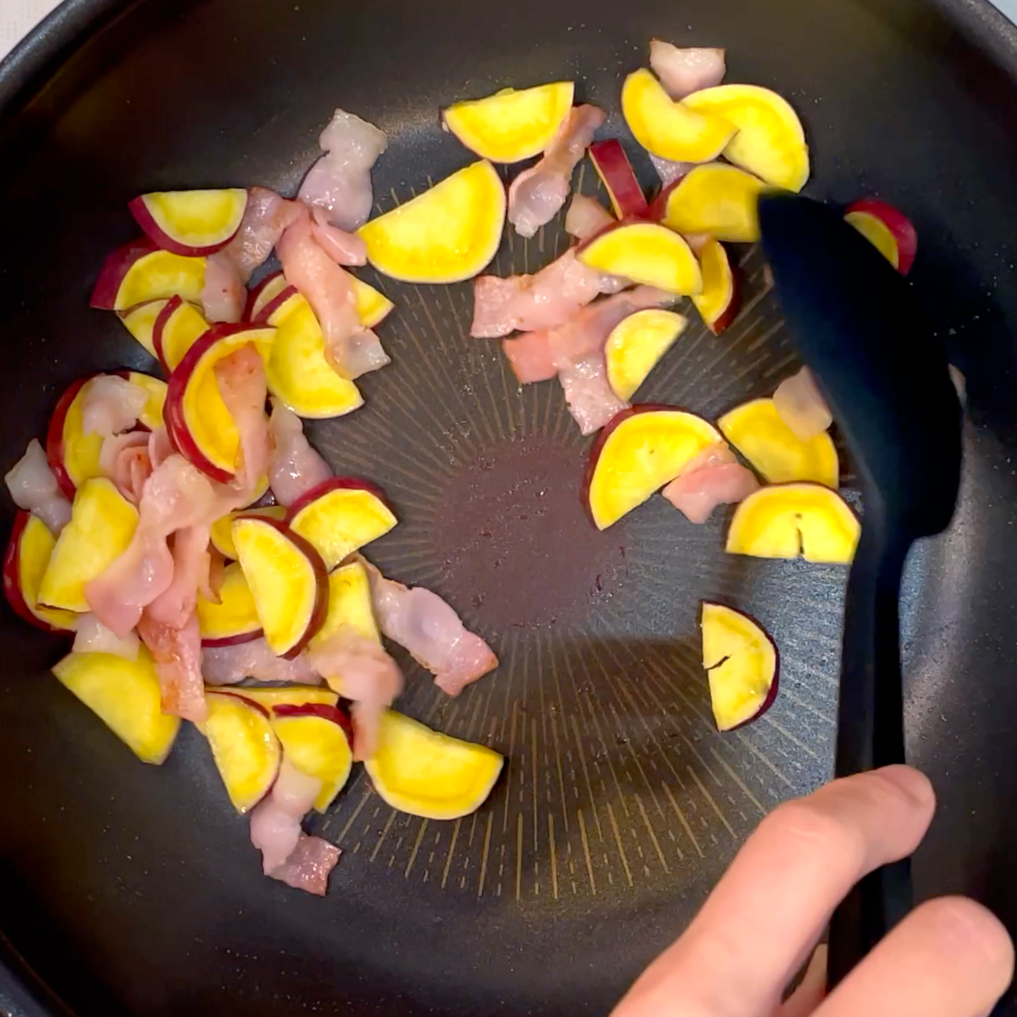 ベーコンとさつまいもを炒め合わせる工程