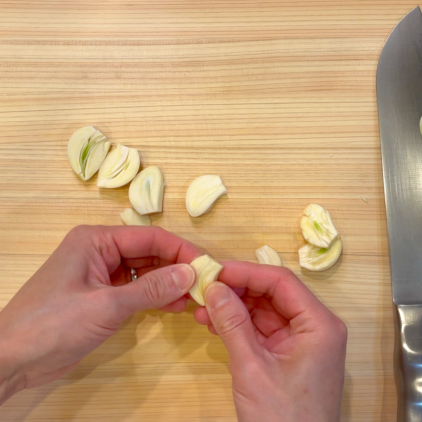 にんにくを半分に切って芽を取り除く工程