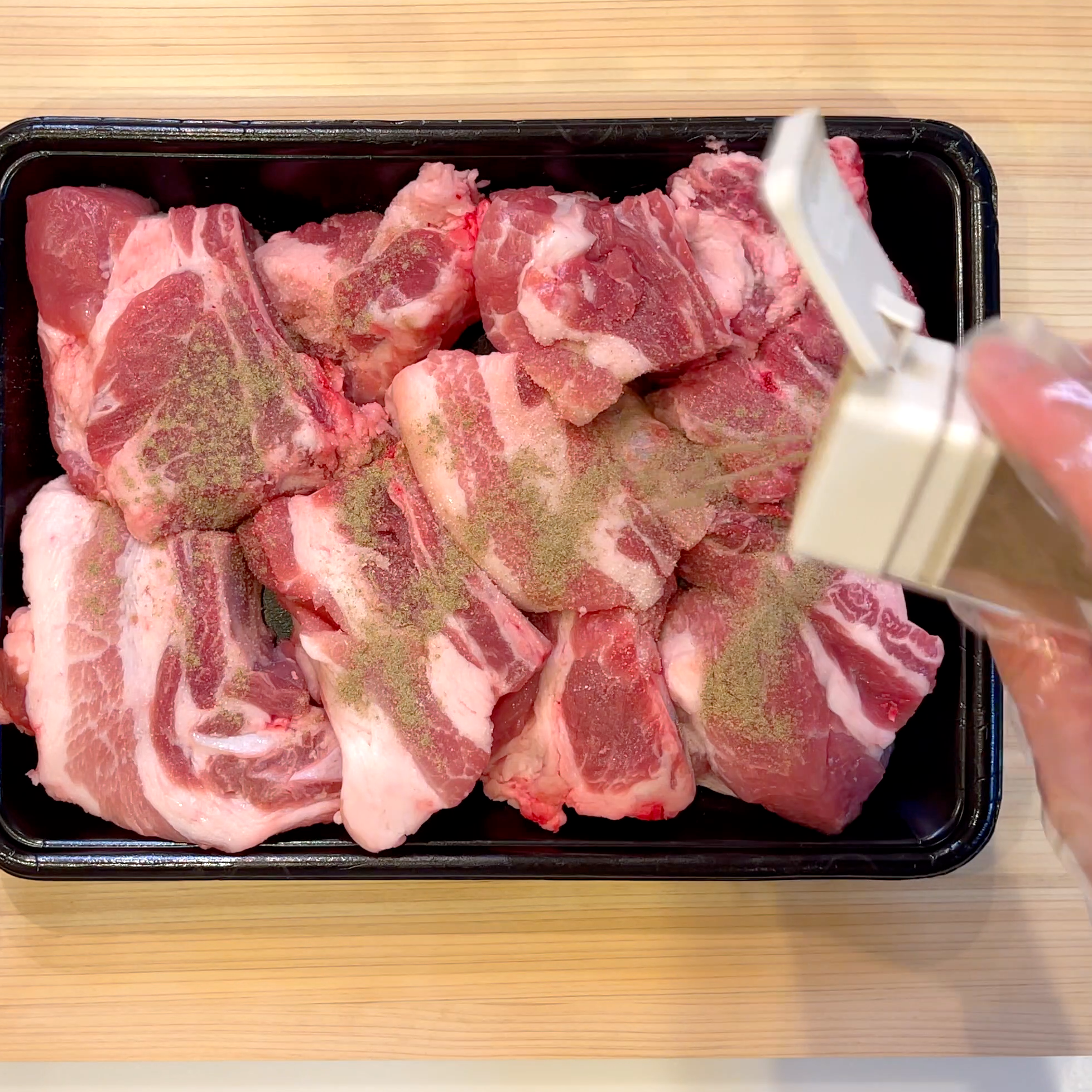 スペアリブに塩こしょうで下味をつける工程