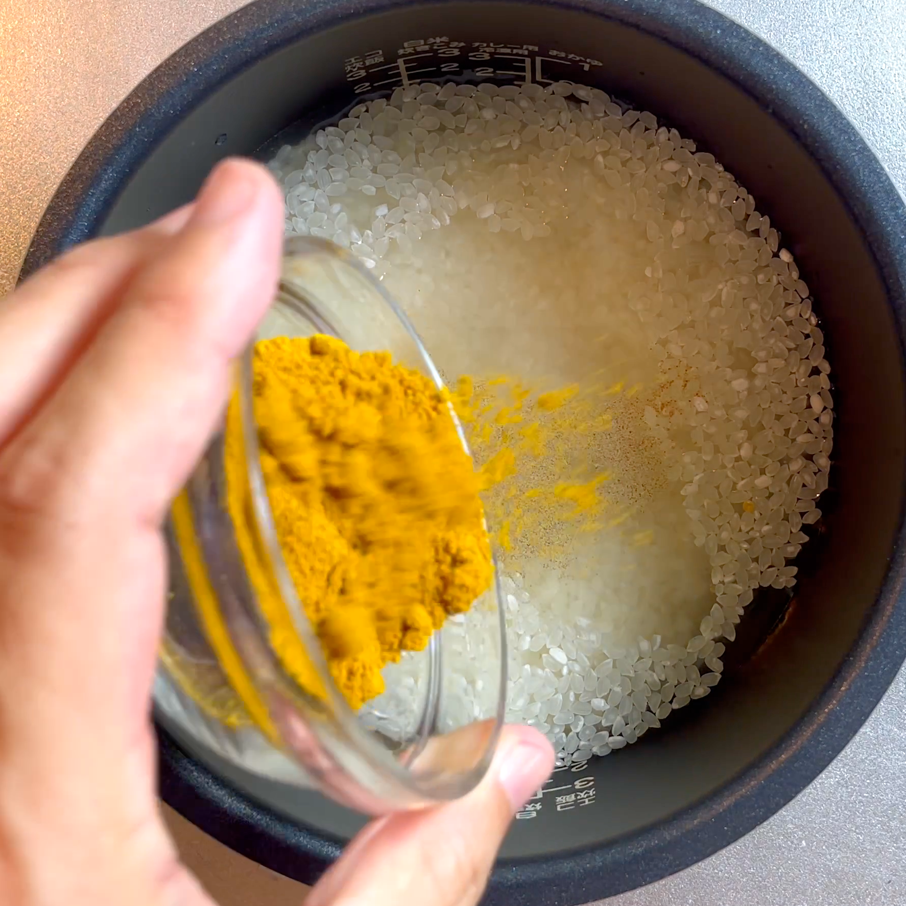 炊飯釜に米と水と調味料を入れてかき混ぜる工程