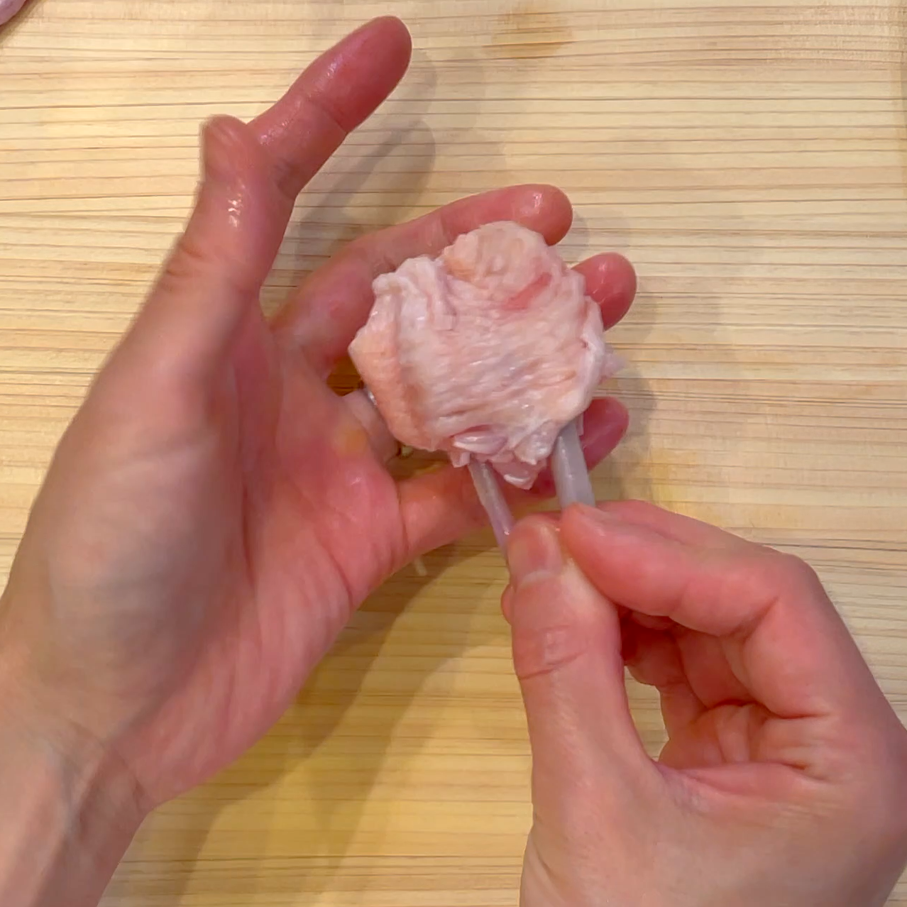 骨を持って肉をチューリップ状に成形する工程