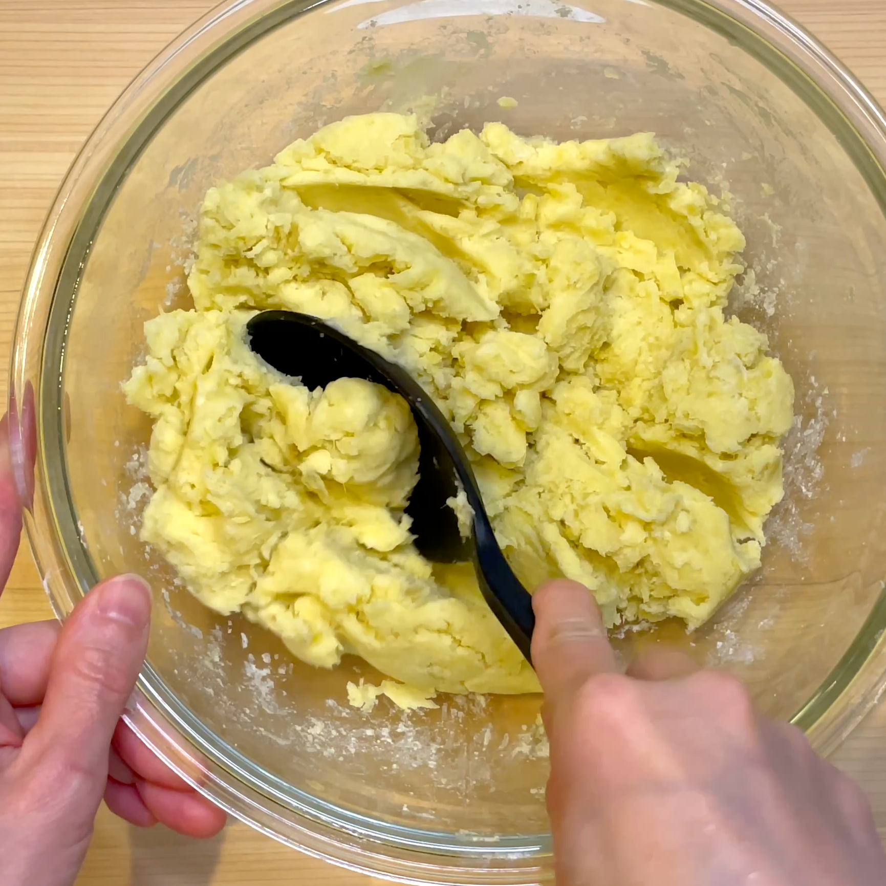 調味料を加えてさつまいもをひとまとめに混ぜる工程