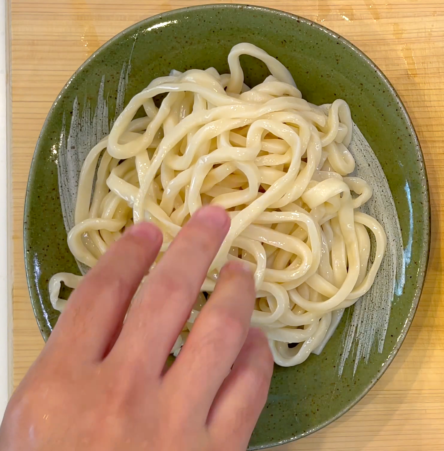 うどんを冷水で洗って盛り付ける工程