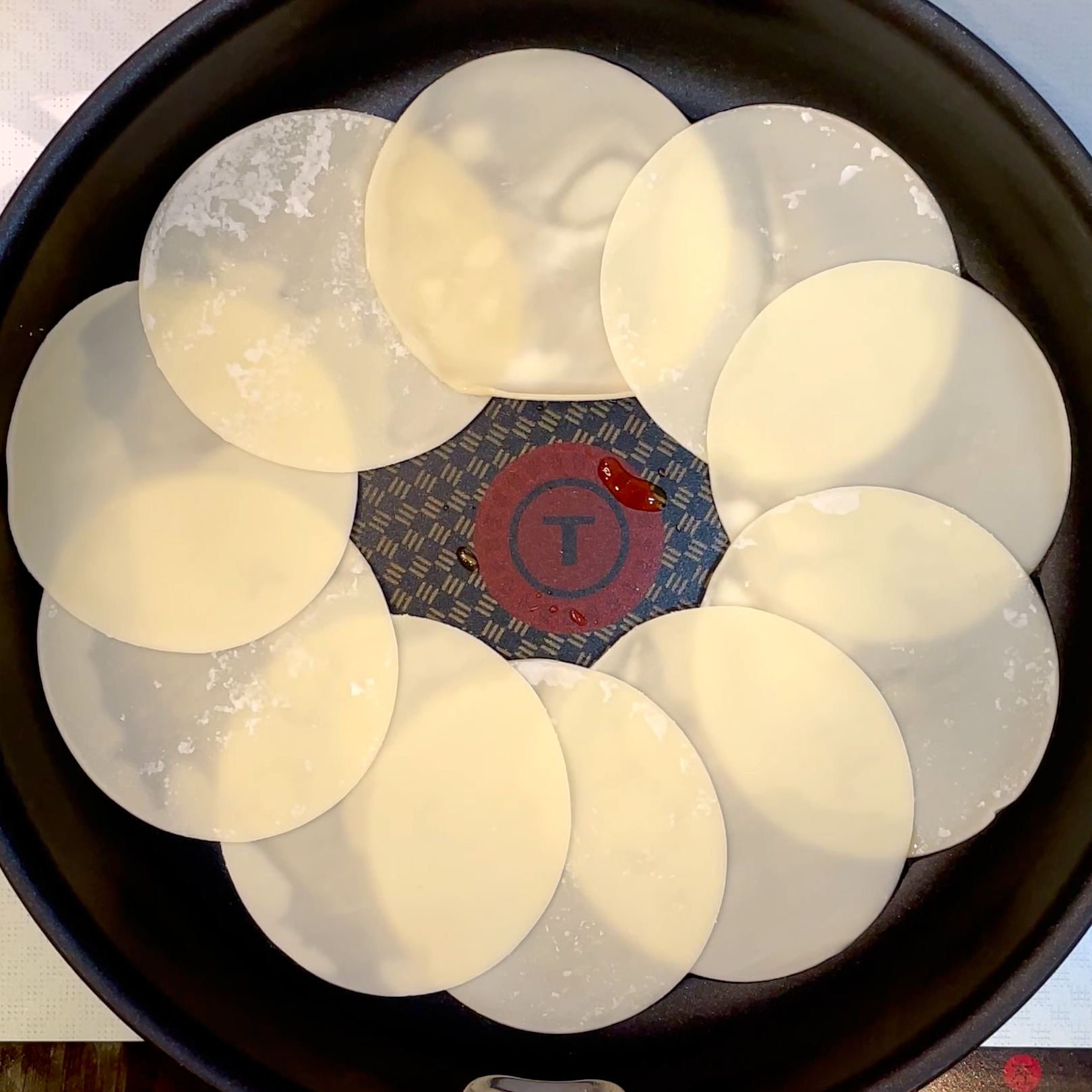 フライパンに餃子の皮を円形に並べる工程