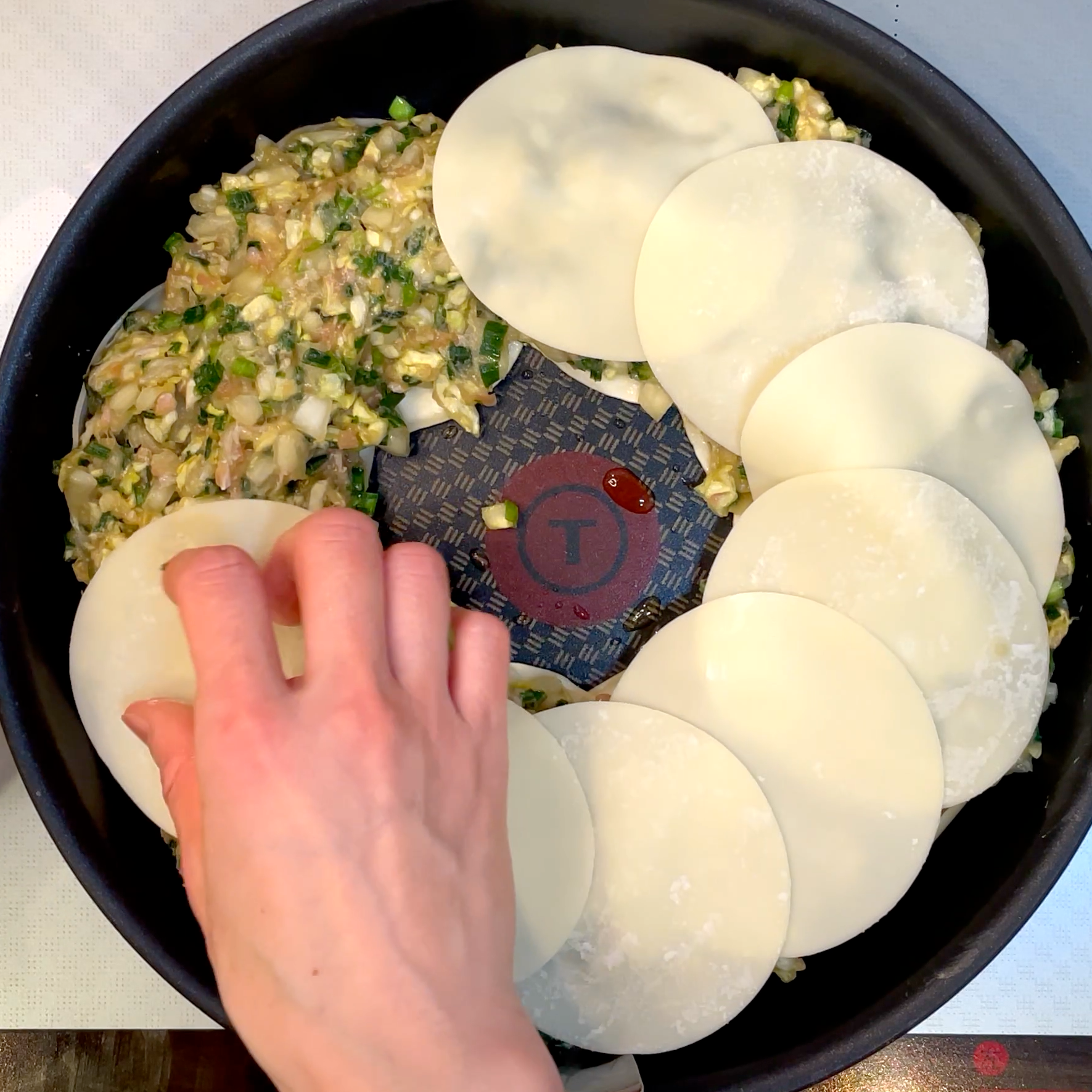 餃子のタネを絞り出し上から皮を重ねる工程