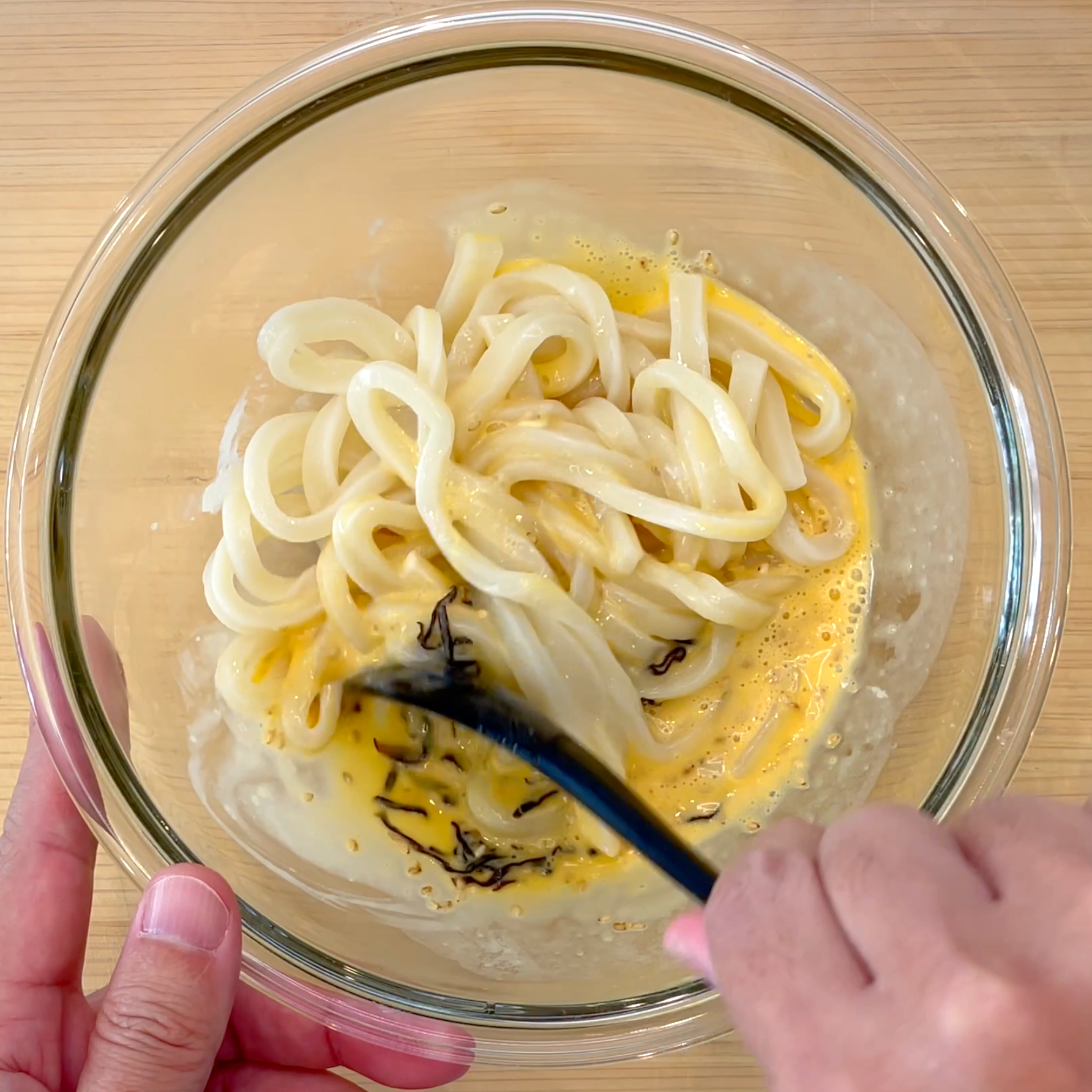うどんを調味料と和える工程