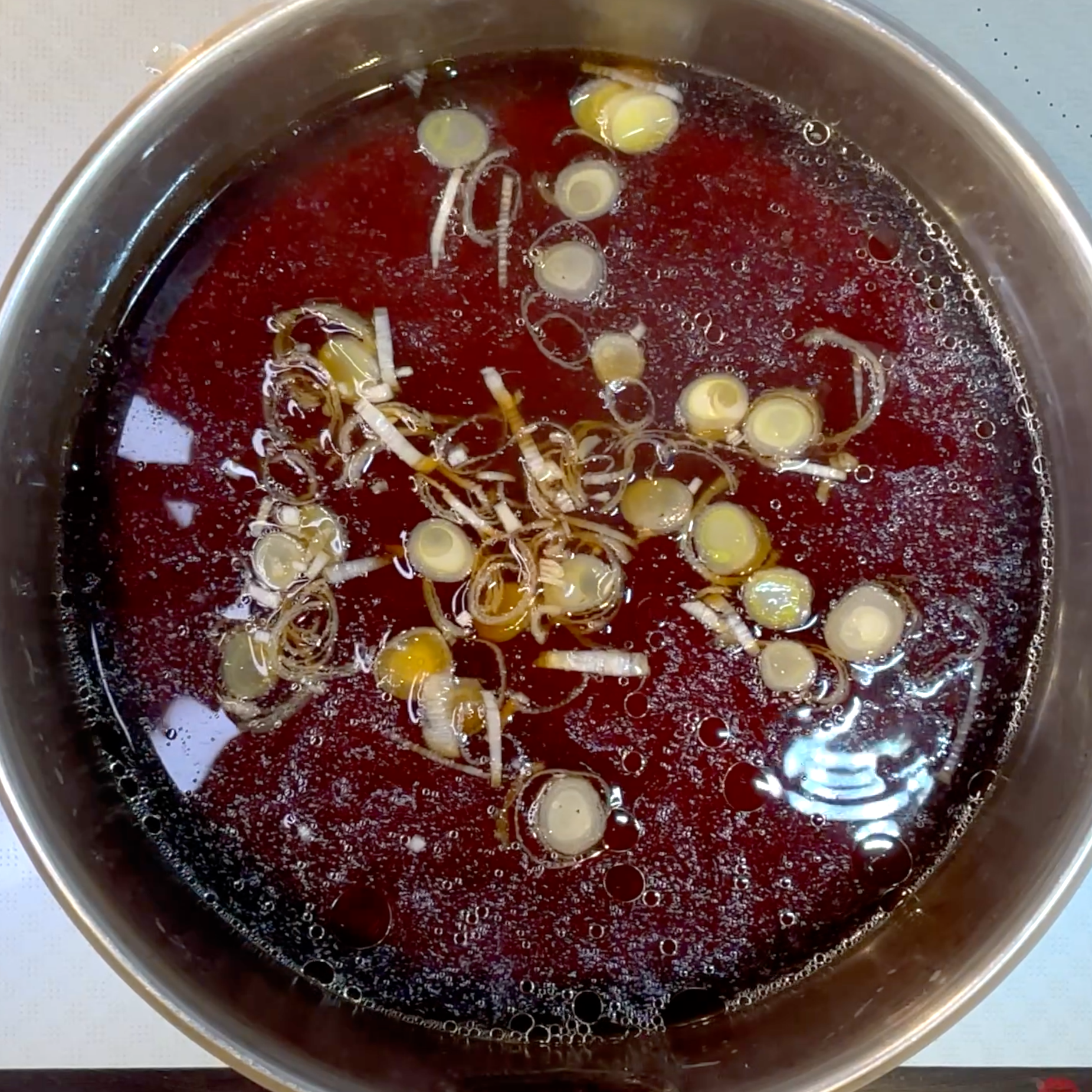 昆布と鶏肉を取り出し、ねぎを加えてつゆを作る工程
