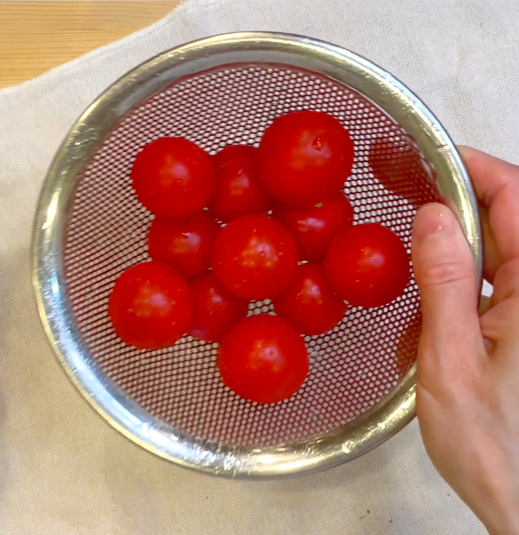 ミニトマトのヘタを取り洗って水気を拭き取る工程