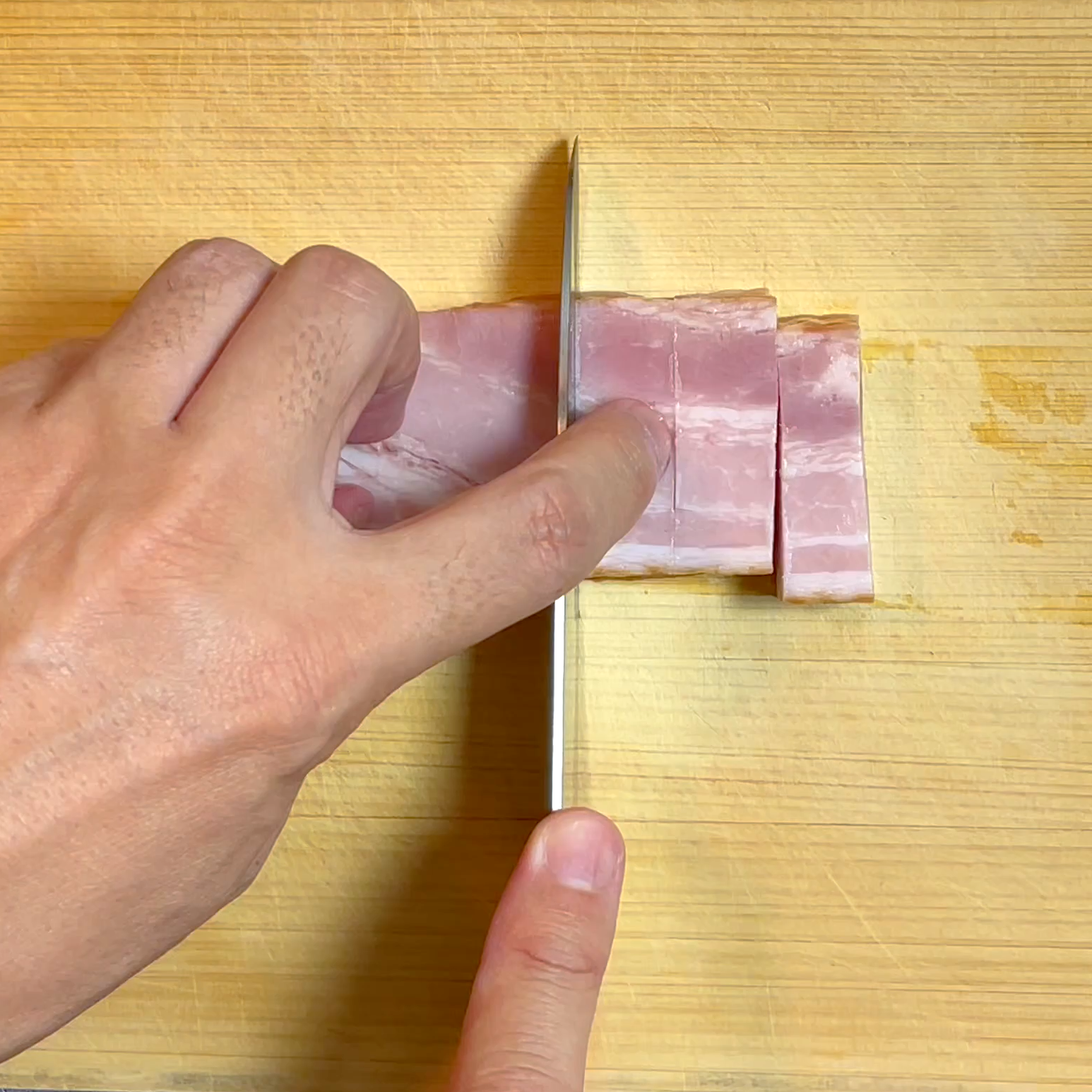 ベーコンを1cm幅に切る工程