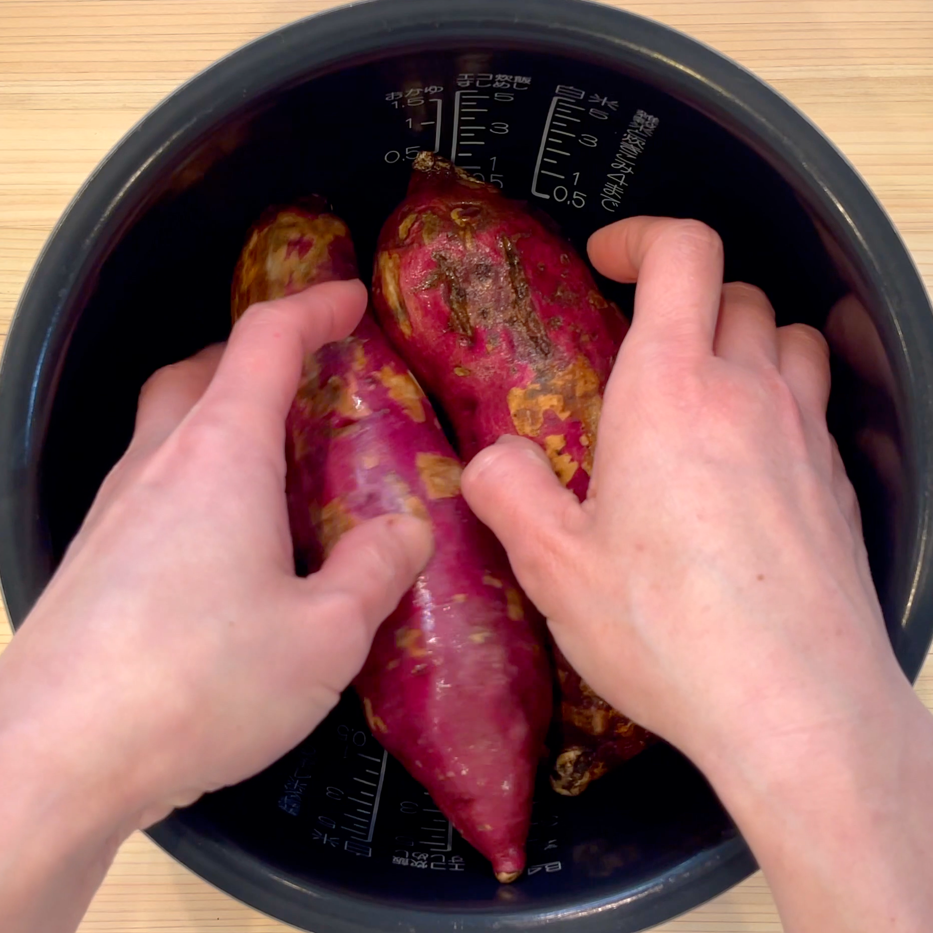 さつまいもを炊飯釜に入れて炊く工程