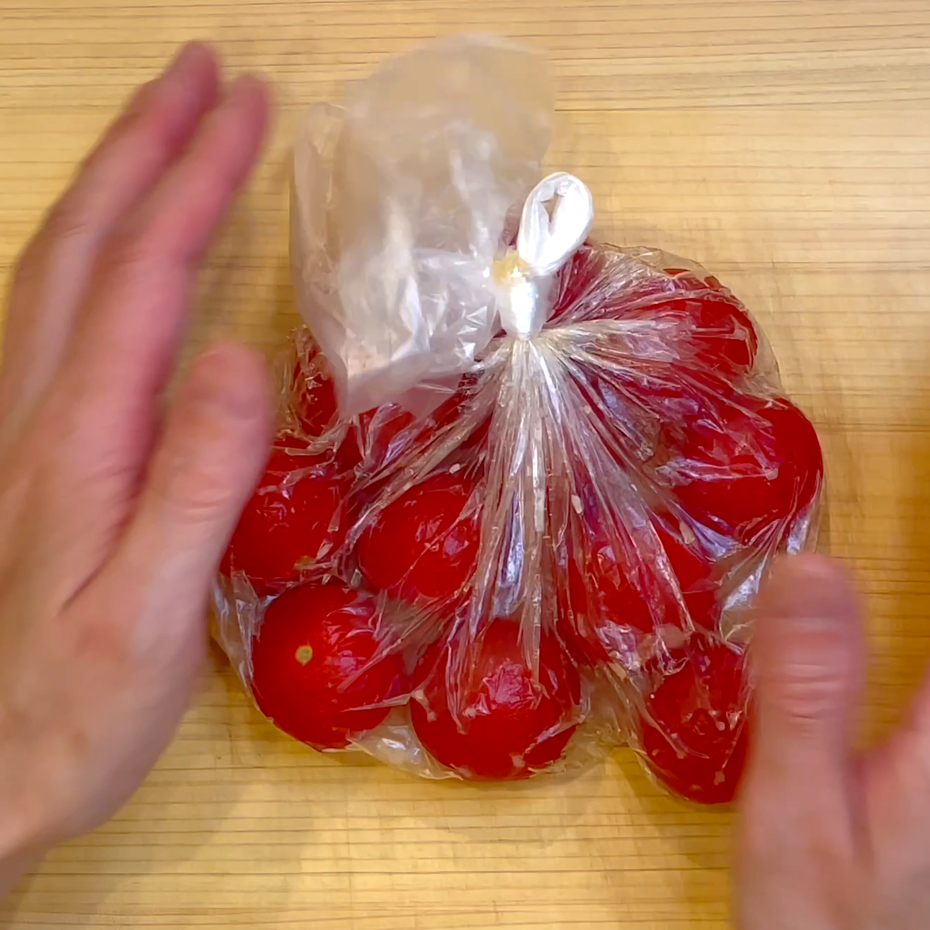 ミニトマトを調味料と一緒にポリ袋で漬け込む工程