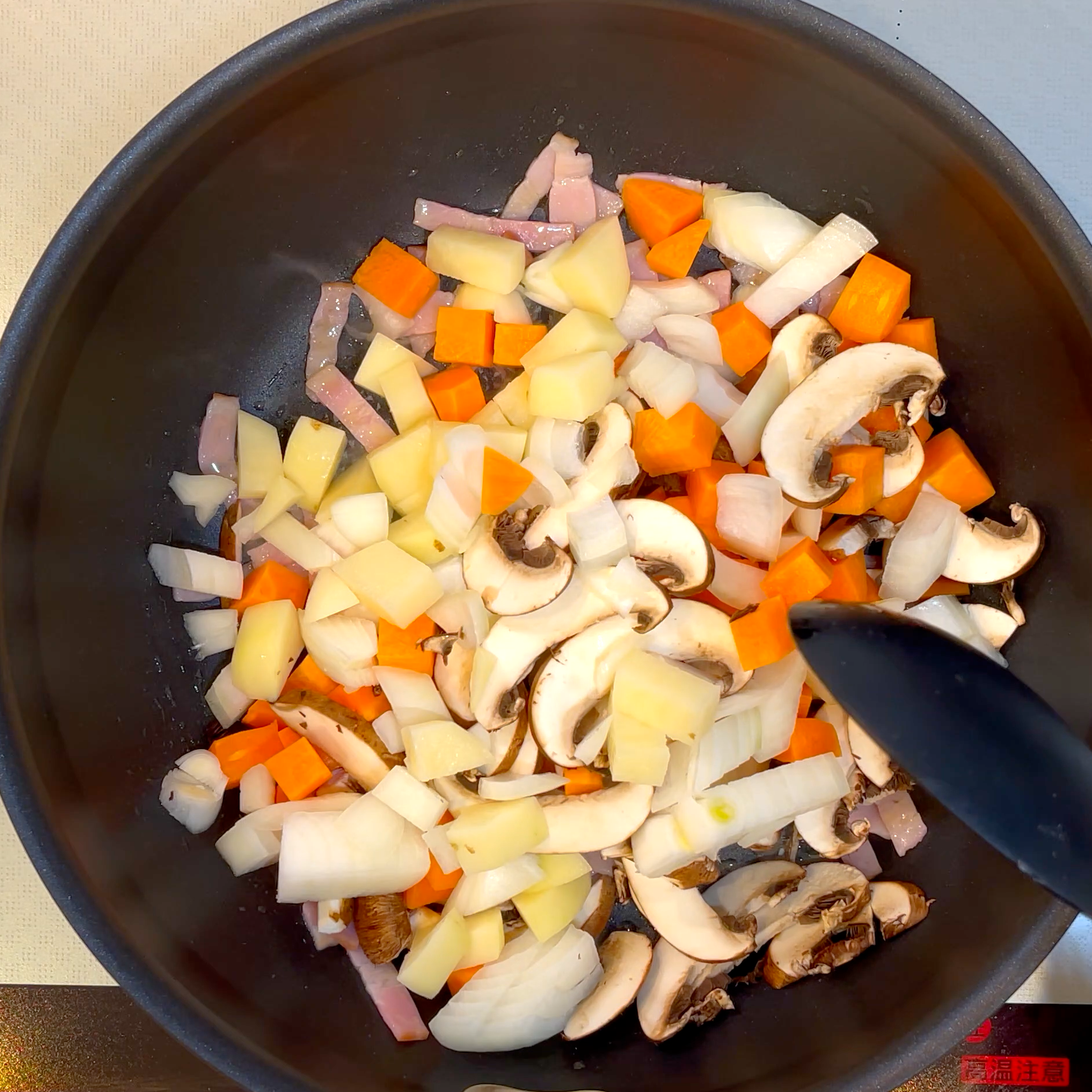 野菜を加えて炒める工程