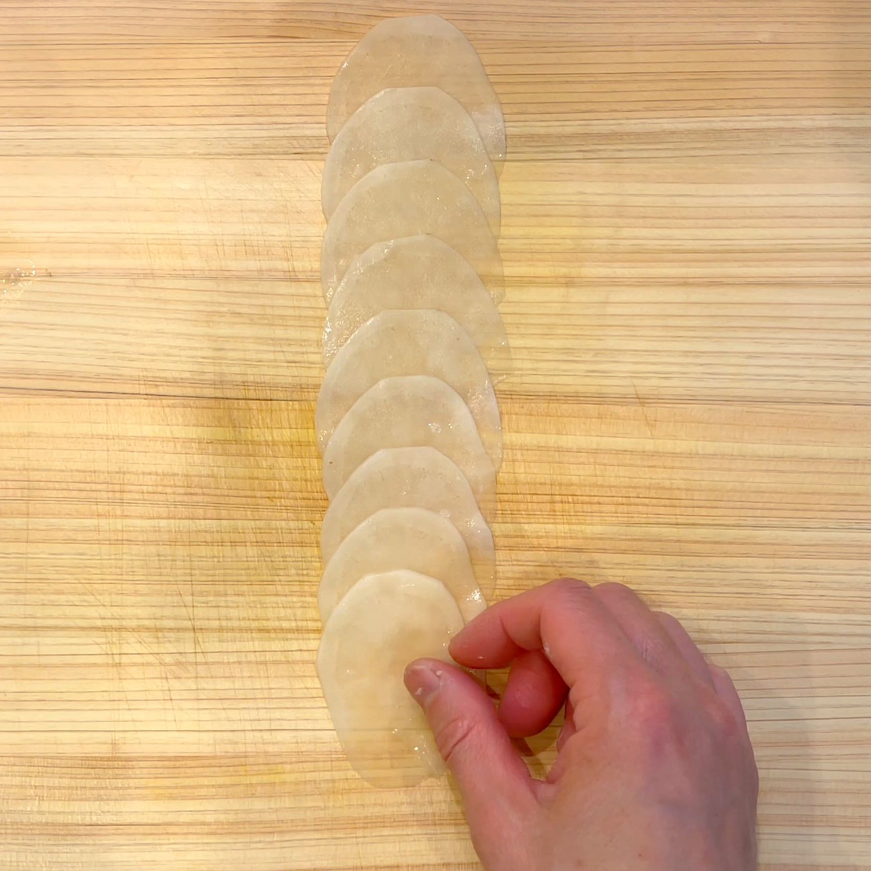 じゃがいもを重ねて巻き爪楊枝で固定する工程