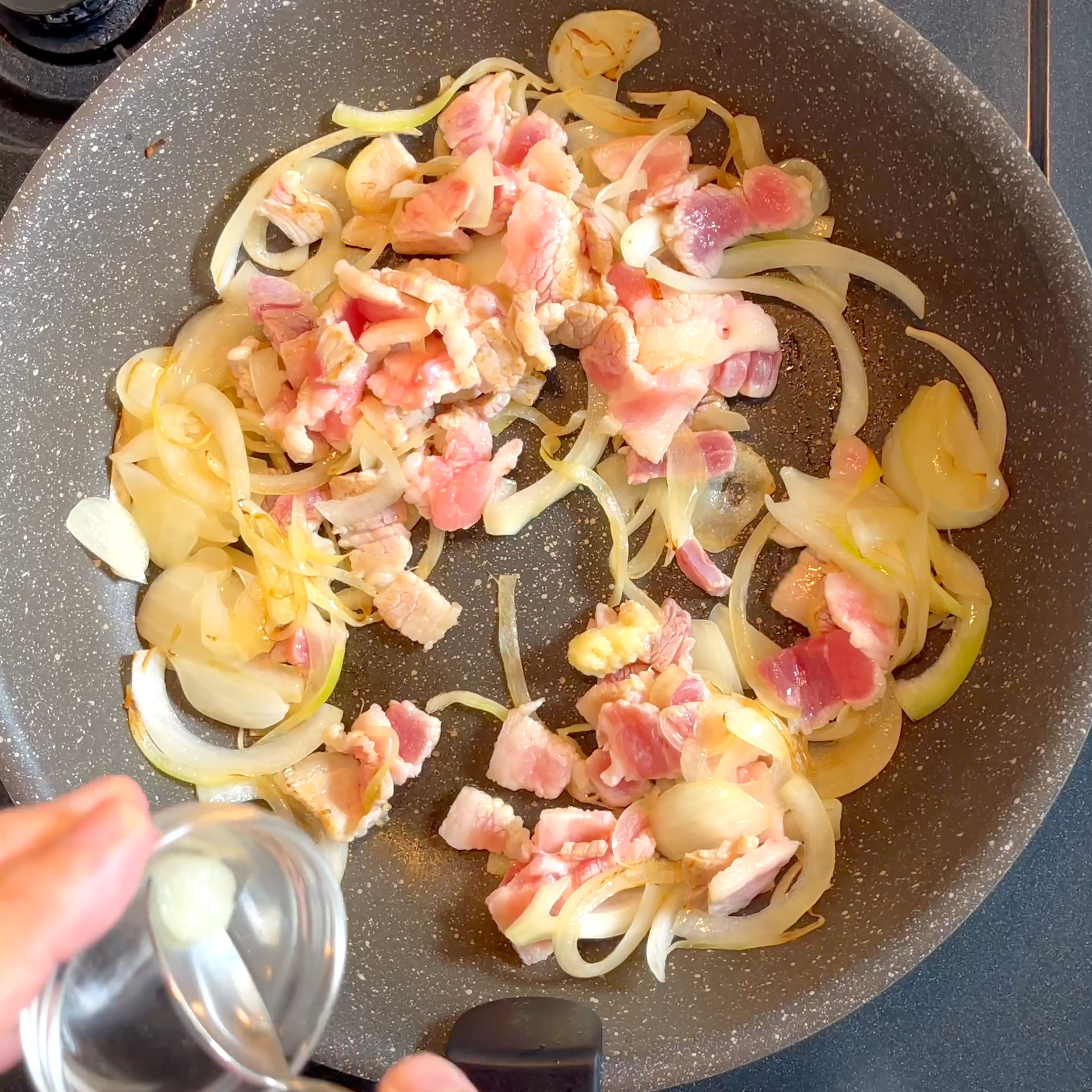 豚バラ肉としょうがとにんにくを加えて炒める工程