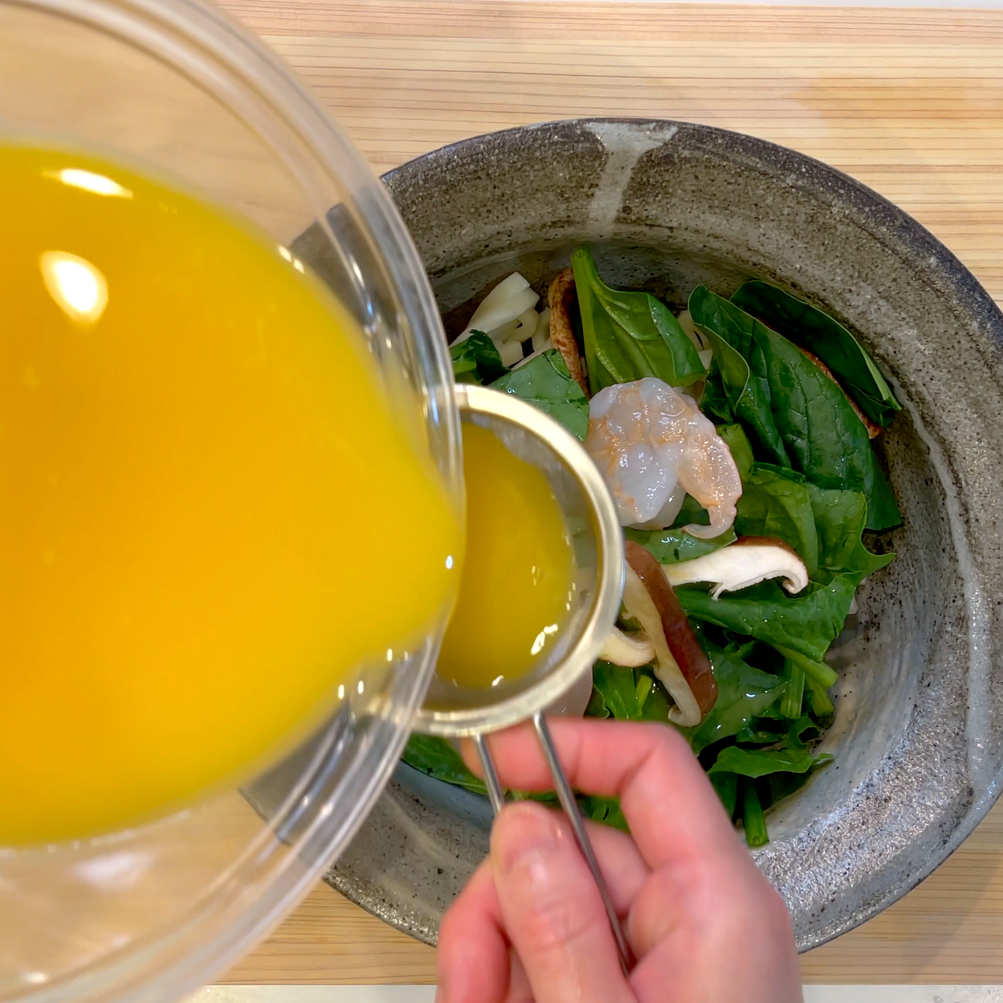 蒸し椀にうどんと具材を入れ卵液を流し入れる工程