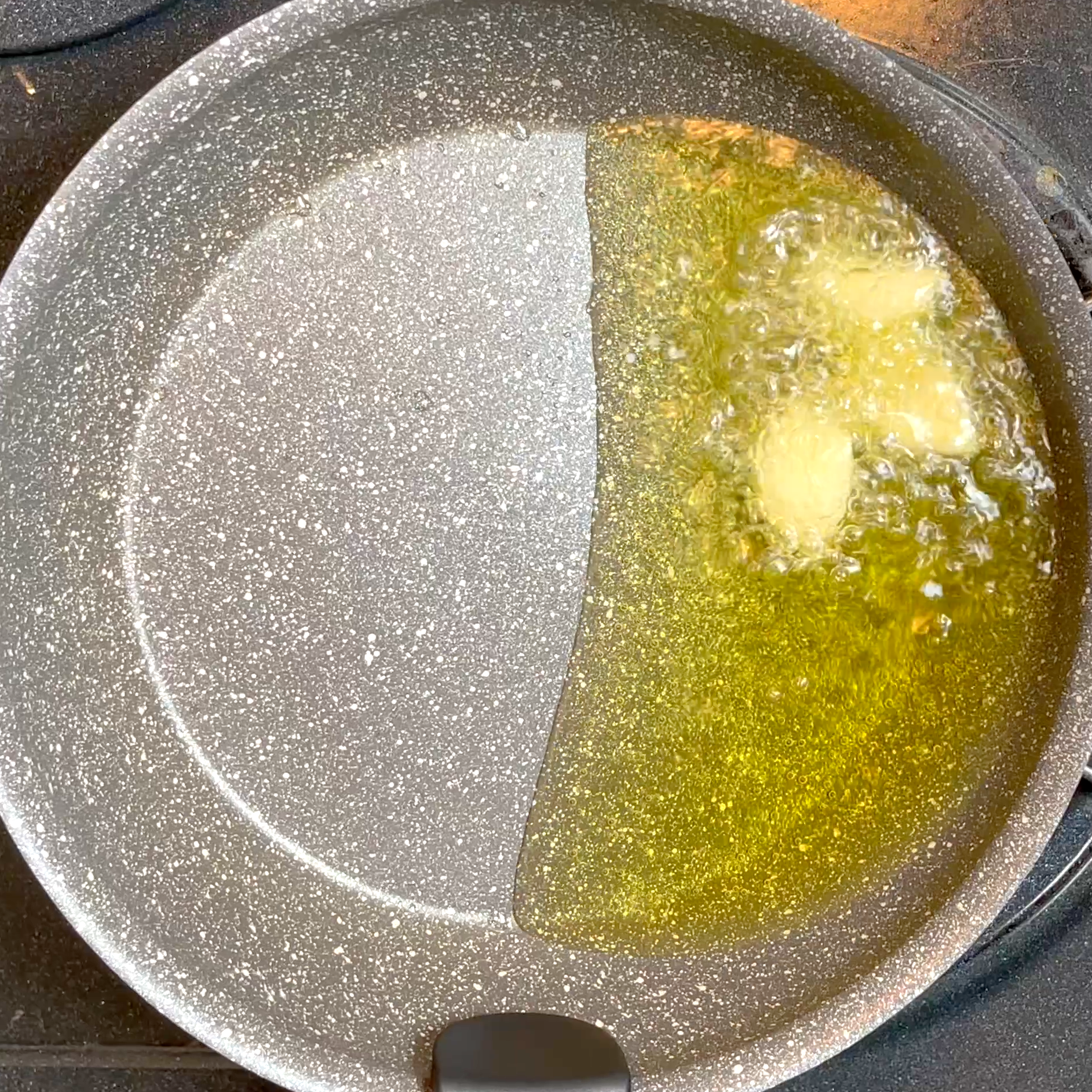 にんにくとオリーブオイルを加熱し香りを出す工程