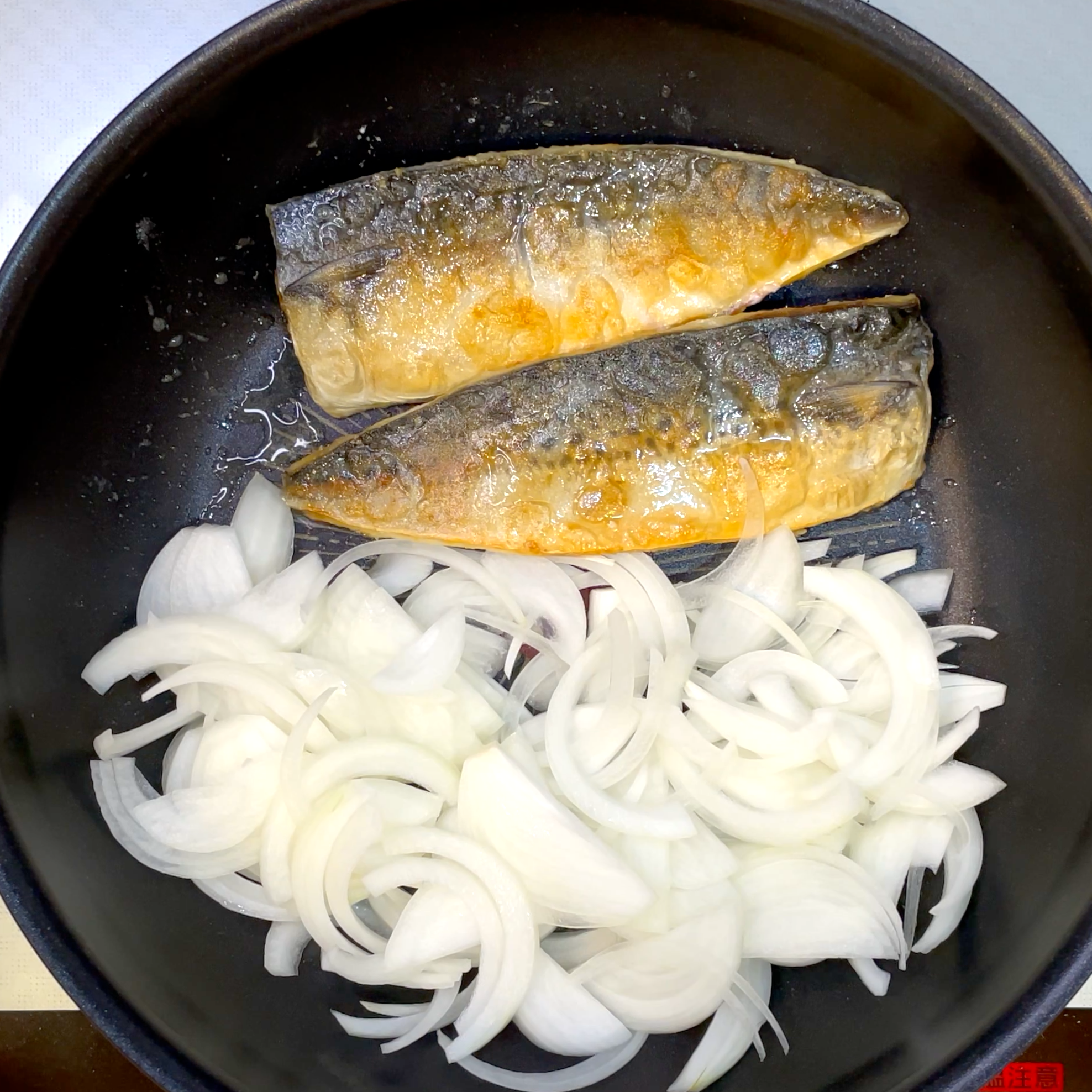 サバをひっくり返しながら玉ねぎを炒める工程