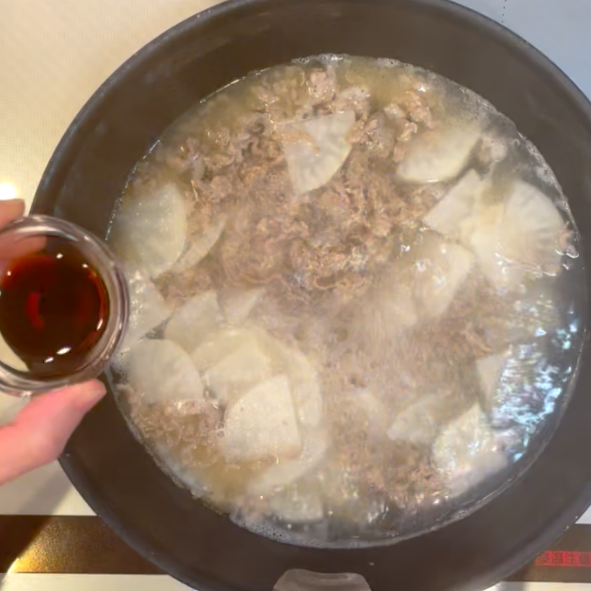 調味料を加えて大根がくたっとするまで煮込む工程