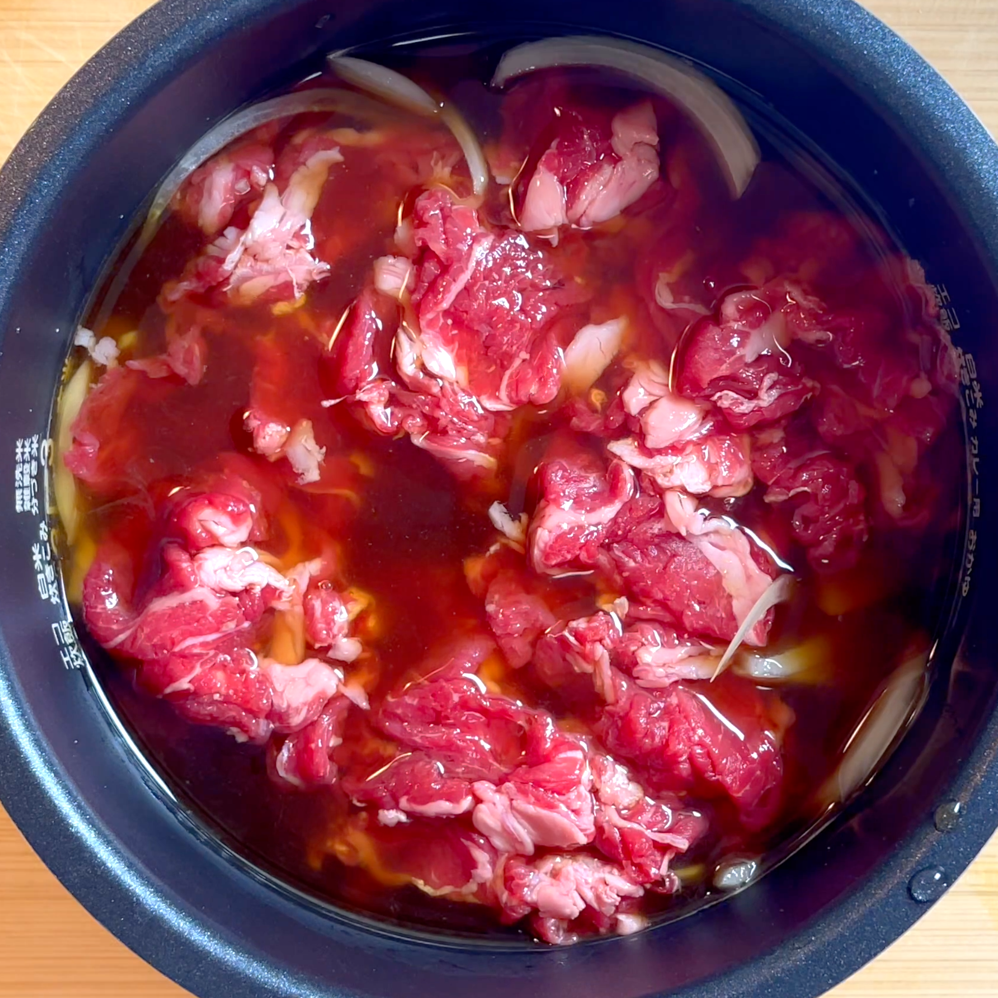 玉ねぎと牛肉をのせて炊飯する工程