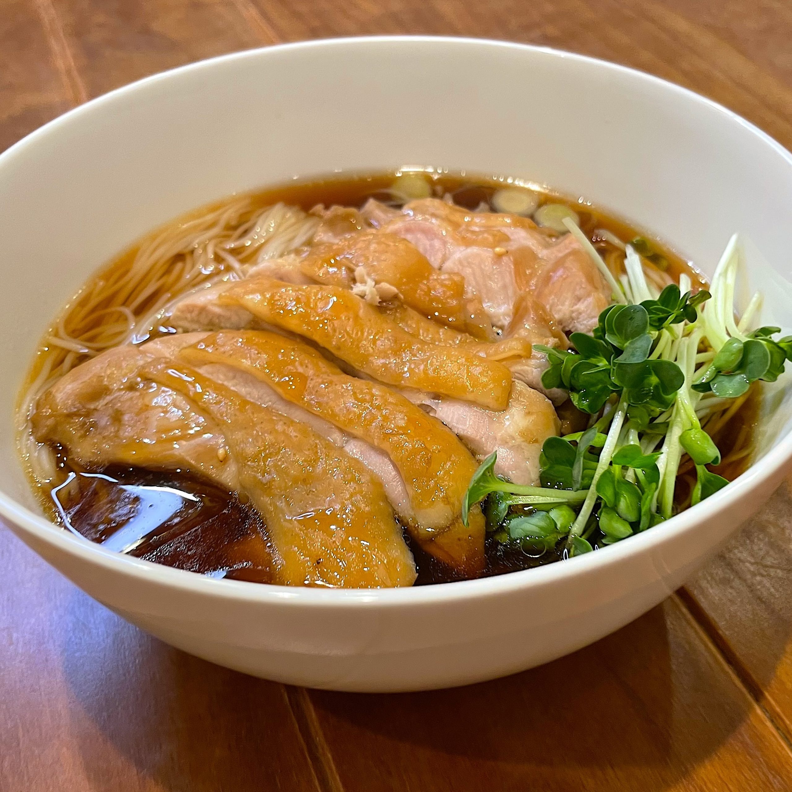 そうめんに鶏肉とつゆをトッピングする盛り付け工程