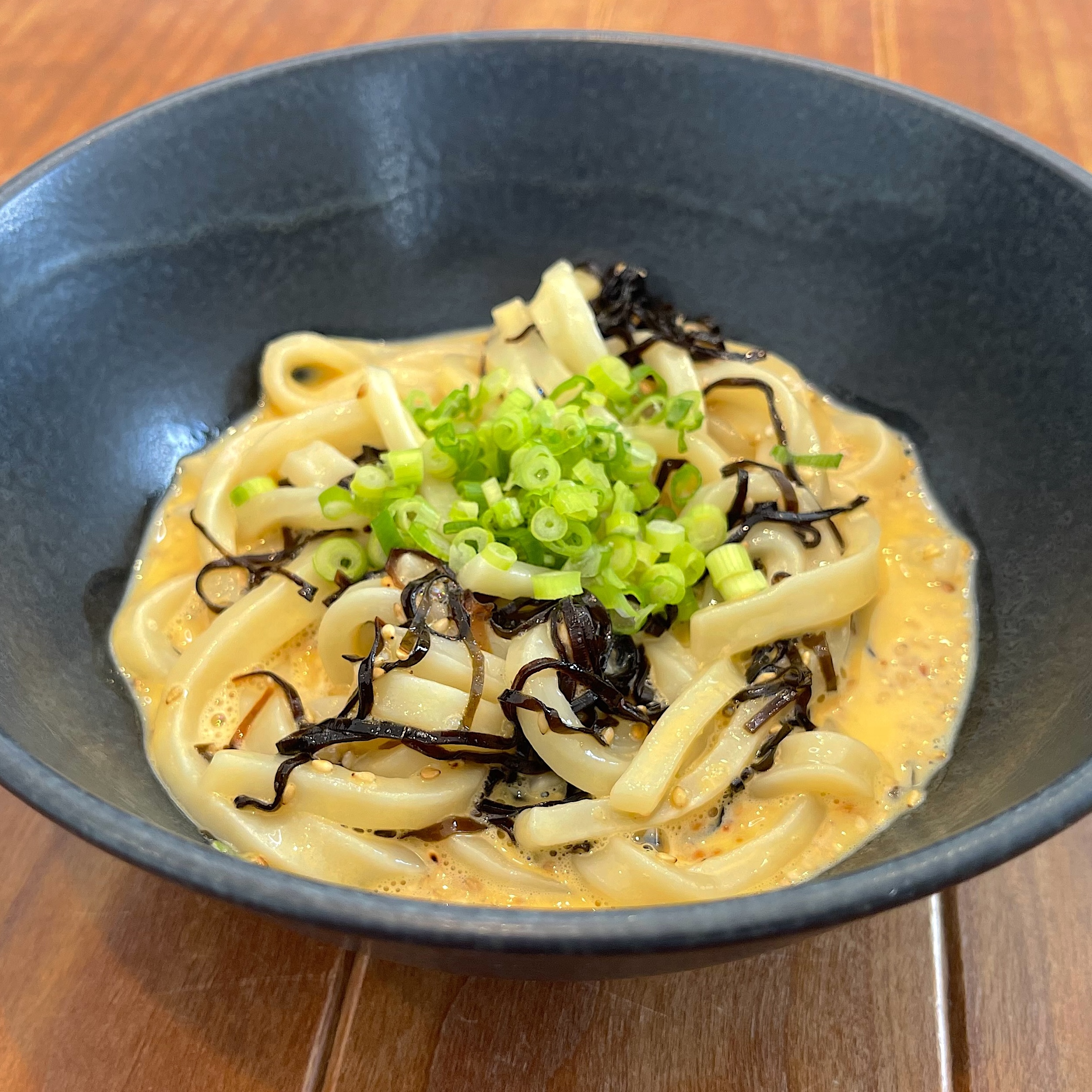 どんぶりに盛り付けて小ねぎを散らす完成工程