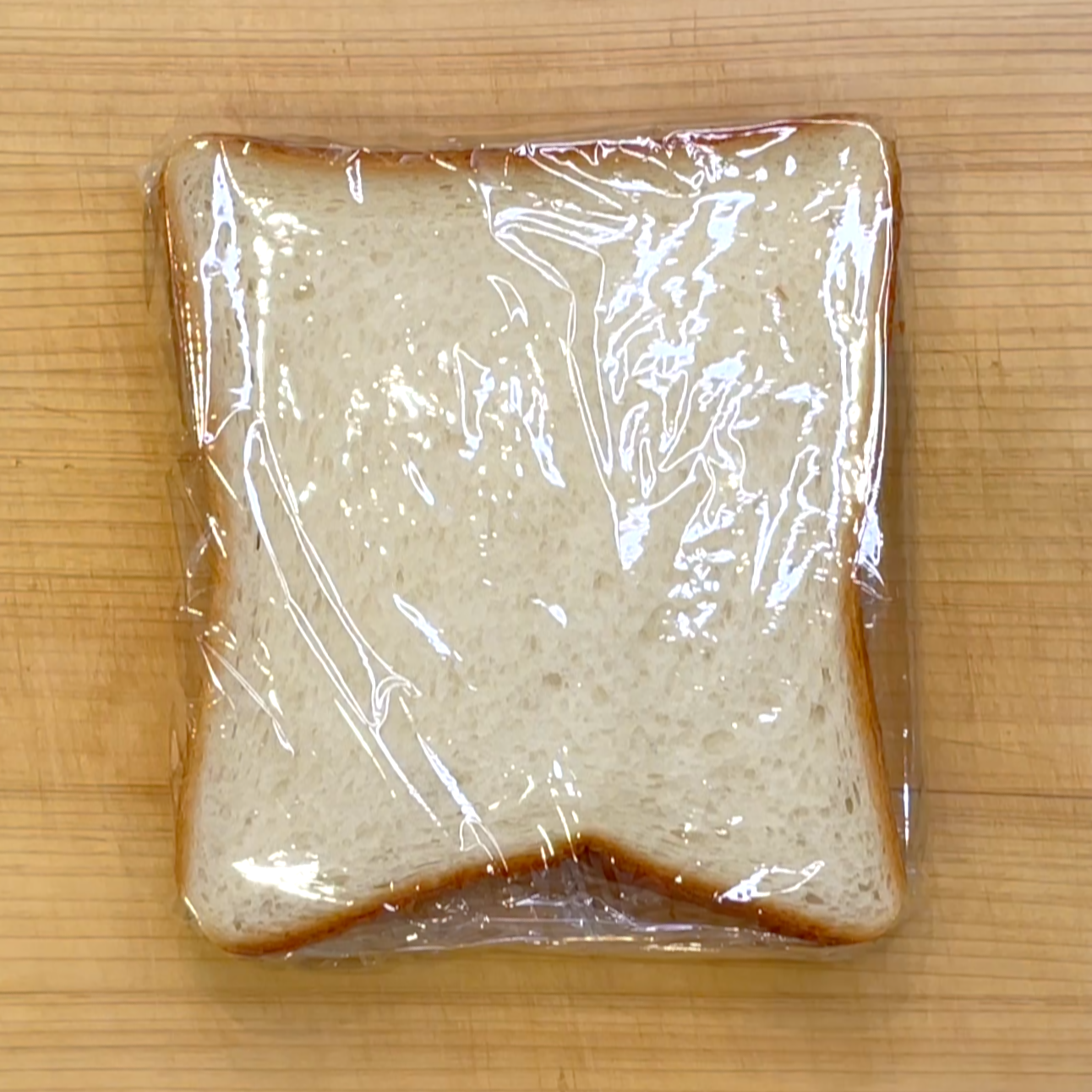 食パンをラップで包んで電子レンジで加熱する工程