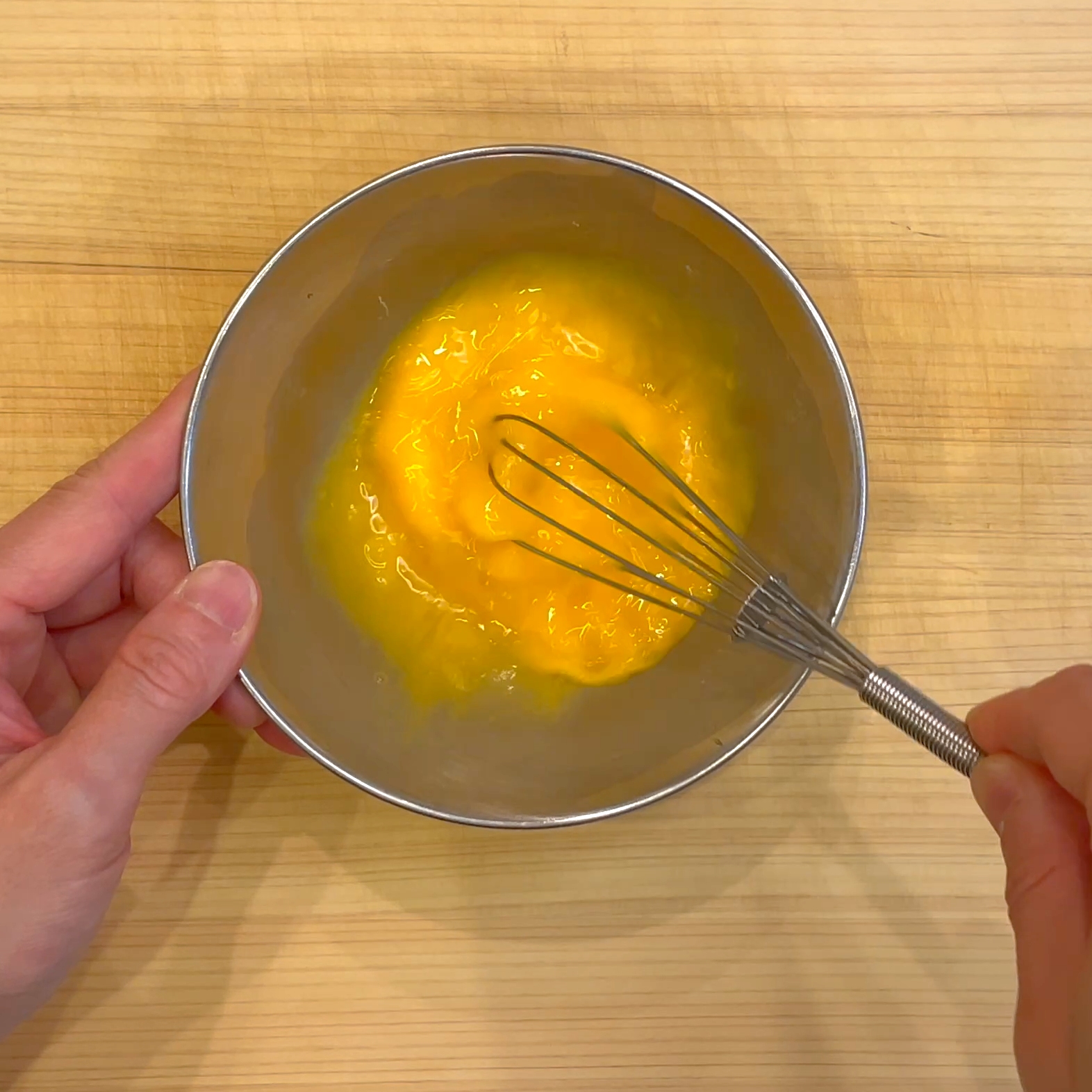 卵を器に割り入れて溶きほぐす工程