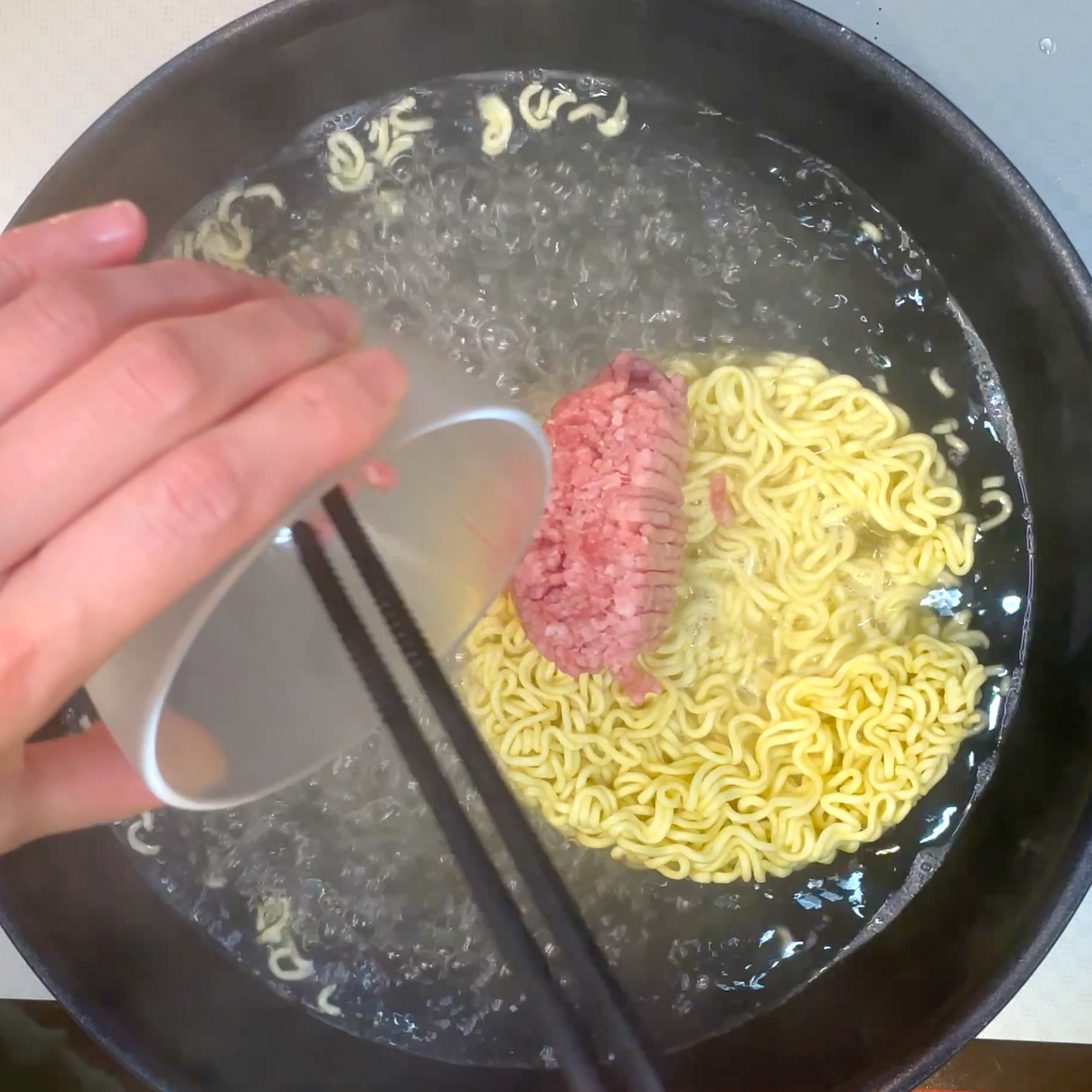 麺と豚ひき肉を茹でる工程