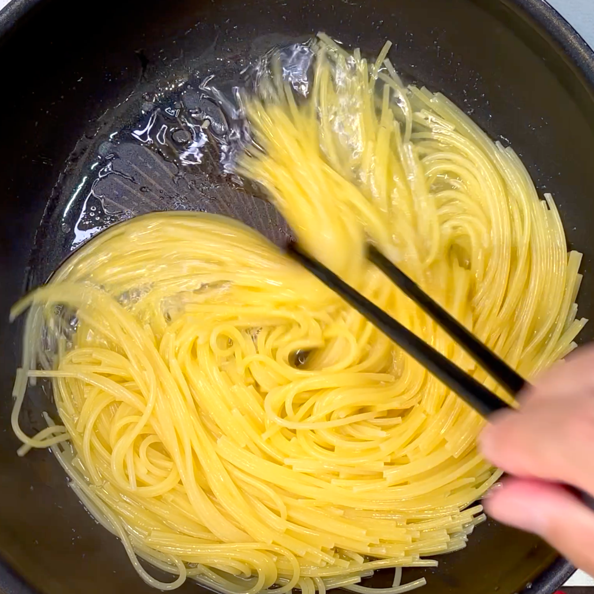 水気を飛ばしながらパスタの硬さを確認する工程