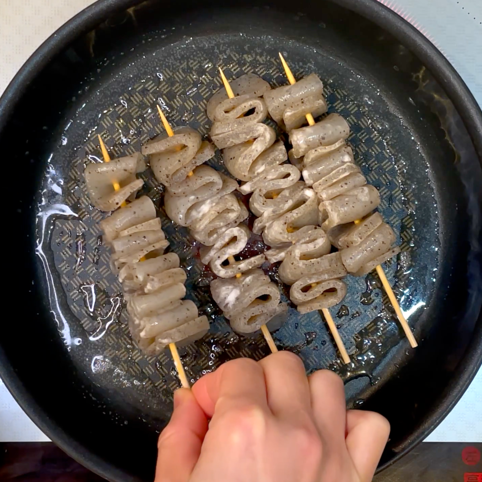 牛脂でこんにゃく串を焼く工程
