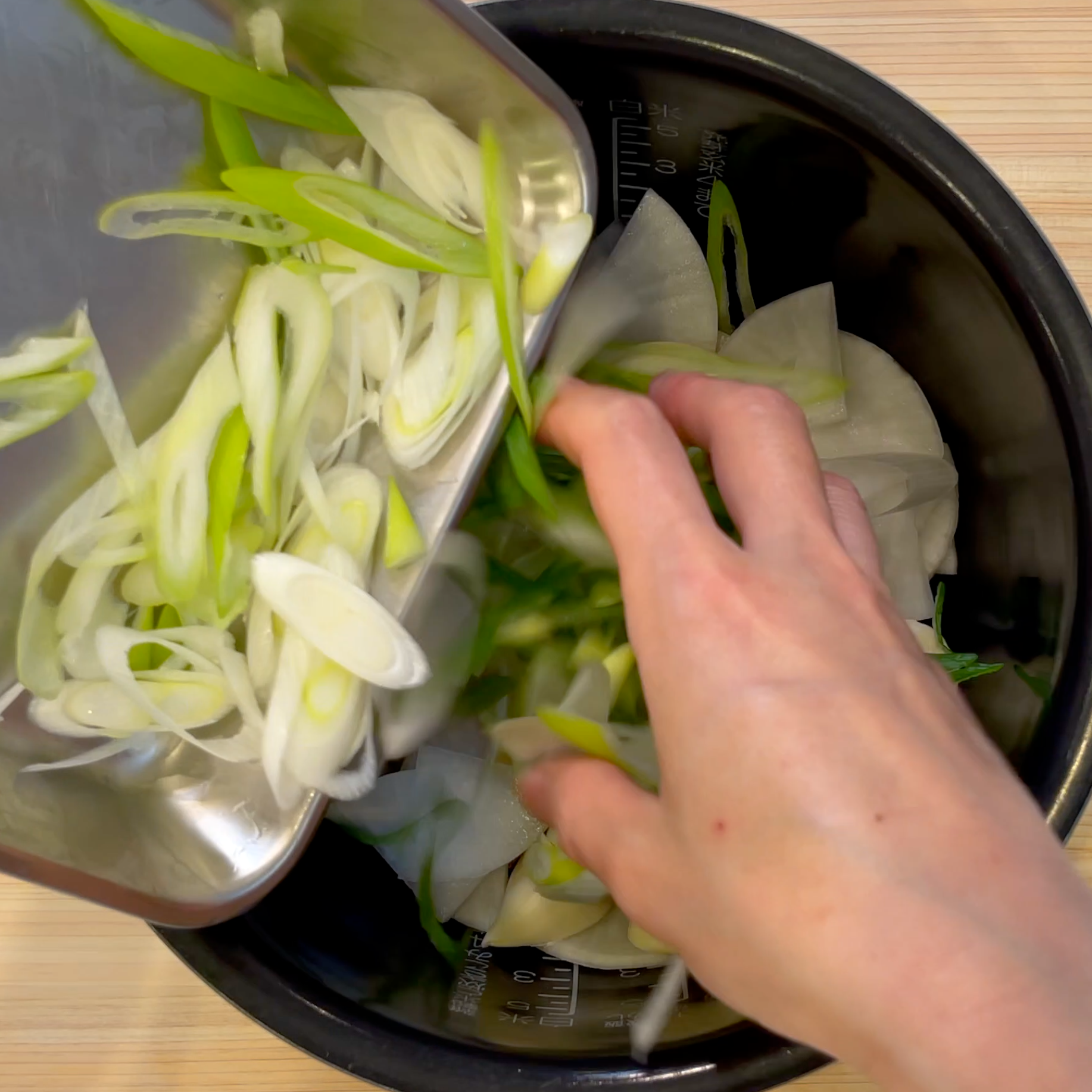 炊飯釜に材料と調味料を入れて混ぜる工程